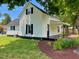 Charming two-story home with white siding, black shutters, and a well-maintained lawn and landscaped garden at 510 May St, Gibsonville, NC 27249