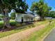 Charming two-story home with white siding, black shutters, and a cozy front porch with landscaping at 510 May St, Gibsonville, NC 27249