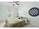 Bright bedroom with light green walls, a window, bed, dart board, and string lights at 5301 Denmead Way, Raleigh, NC 27613
