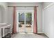 Dining area with sliding doors opening to a wooden deck and featuring pink curtains and gray tile floor at 5301 Denmead Way, Raleigh, NC 27613