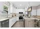 Modern kitchen featuring white cabinets, stone countertops, stainless steel appliances, and island at 5301 Denmead Way, Raleigh, NC 27613