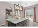 Kitchen island with marble countertop and modern pendant lighting open to dining area with sliding glass doors to the deck at 5301 Denmead Way, Raleigh, NC 27613