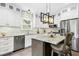 Bright kitchen features white cabinets, stainless appliances, marble countertops, and a modern pendant lighting fixture at 5301 Denmead Way, Raleigh, NC 27613