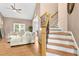 Cozy living room featuring hardwood floors, a ceiling fan, and staircase with decorative iron spindles at 5301 Denmead Way, Raleigh, NC 27613