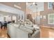Open-concept living space with hardwood floors, staircase, and a large sectional sofa at 5301 Denmead Way, Raleigh, NC 27613