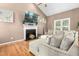 Comfortable living room with fireplace, mounted TV, and a large sectional sofa at 5301 Denmead Way, Raleigh, NC 27613
