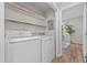 Bright laundry room featuring white washer, dryer, and shelving for storage at 5721 Meadow, Knightdale, NC 27545