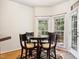 Cozy breakfast nook with a glass table, wood chairs, and sun-filled windows overlooking a lush yard at 5818 Myakka Ct, Raleigh, NC 27616
