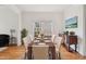 Dining room with hardwood floors, white trim, and a window complemented by a dining table and sideboard at 5818 Myakka Ct, Raleigh, NC 27616