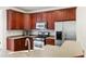 Kitchen with stainless steel appliances, dark wood cabinets, and grey countertops at 5818 Myakka Ct, Raleigh, NC 27616