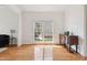 Bright living room featuring hardwood floors, white trim, and a large window providing natural light at 5818 Myakka Ct, Raleigh, NC 27616