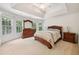 Bright main bedroom with a tray ceiling, neutral carpet, a bed, and multiple windows at 5818 Myakka Ct, Raleigh, NC 27616