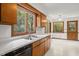 Sunlit kitchen with natural wood cabinets, stainless steel sink, and a view of the surrounding greenery at 601 Wofford Rd, Durham, NC 27707