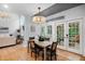 Dining room featuring a chandelier, hardwood floors, and access to the back porch at 602 Preston Village Way, Cary, NC 27519