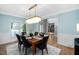 This dining room features modern chandelier, light blue walls with white trim, and an elegant wood dining table at 602 Preston Village Way, Cary, NC 27519