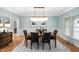 Formal dining area with hardwood floors, modern chandelier, and wainscoting at 602 Preston Village Way, Cary, NC 27519