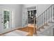 Inviting home foyer with hardwood floors, elegant staircase, and view into office space at 602 Preston Village Way, Cary, NC 27519