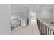 Hallway features neutral carpet, decorative railings, and ample lighting at 602 Preston Village Way, Cary, NC 27519