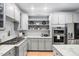 Charming kitchen with stainless steel appliances, granite countertops, and open shelving at 602 Preston Village Way, Cary, NC 27519