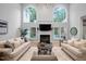 Bright living room with fireplace, high ceilings, lots of windows, hardwood floors and neutral furniture at 602 Preston Village Way, Cary, NC 27519