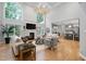 Open-concept living room with fireplace, large windows, hardwood floors and elegant lighting at 602 Preston Village Way, Cary, NC 27519