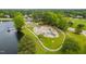 Expansive community playground features modern equipment surrounded by lush greenery and a serene lake at 602 Preston Village Way, Cary, NC 27519