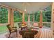 A screened porch with wicker furniture, curtains, and a swing for relaxed outdoor living at 602 Preston Village Way, Cary, NC 27519