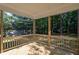 View of covered deck featuring wood flooring and railing overlooking trees at 6069 Jones Cir, Sanford, NC 27332