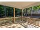 View of covered deck featuring wood flooring and railing overlooking treed backyard at 6069 Jones Cir, Sanford, NC 27332