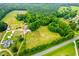 Aerial view of property, nestled amongst lush greenery and farmland at 6318 Hurdle Mills Rd, Roxboro, NC 27574