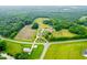 Wide aerial shot of property, nestled between lush foliage, farmland and road access at 6318 Hurdle Mills Rd, Roxboro, NC 27574