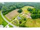 Stunning aerial view of property, featuring a charming home, farmland and lush green forest at 6318 Hurdle Mills Rd, Roxboro, NC 27574