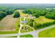 Aerial view of property featuring a home, farmland, outbuildings and road access at 6318 Hurdle Mills Rd, Roxboro, NC 27574