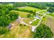 Detailed aerial perspective featuring a home, outbuildings, and extensive land at 6318 Hurdle Mills Rd, Roxboro, NC 27574