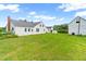 Spacious backyard with well-maintained lawn, leading to the house and an additional white outbuilding at 6318 Hurdle Mills Rd, Roxboro, NC 27574