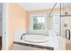 Relaxing bathroom with a soaking tub, separate shower, and a window with outdoor views at 6318 Hurdle Mills Rd, Roxboro, NC 27574