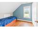 Bright bedroom with blue accent wall, hardwood floors and natural light from window at 6318 Hurdle Mills Rd, Roxboro, NC 27574
