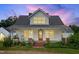 Charming home featuring a metal roof, inviting front porch, and beautiful landscaping at 6318 Hurdle Mills Rd, Roxboro, NC 27574