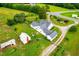Aerial view of home with a metal roof and additional outbuildings, surrounded by mature trees at 6318 Hurdle Mills Rd, Roxboro, NC 27574