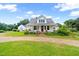 Classic farmhouse with covered porch, vibrant landscaping, and spacious front yard at 6318 Hurdle Mills Rd, Roxboro, NC 27574