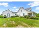 Charming white farmhouse with metal roof and a beautifully landscaped front yard and covered front porch at 6318 Hurdle Mills Rd, Roxboro, NC 27574