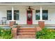 Close-up of the charming front porch featuring classic columns and brick stairs at 6318 Hurdle Mills Rd, Roxboro, NC 27574