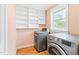 Bright laundry room features wooden floors, modern washer and dryer and built in shelving at 6318 Hurdle Mills Rd, Roxboro, NC 27574