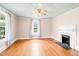 Bright living room with hardwood floors, fireplace, and large windows offering abundant natural light at 6318 Hurdle Mills Rd, Roxboro, NC 27574