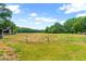 Wide pasture bordered by a wooden fence, trees and barns is perfect for livestock or recreation at 6318 Hurdle Mills Rd, Roxboro, NC 27574