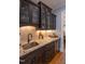 Elegant bar area with granite countertop, dark wood cabinets, wine cooler, and stylish backsplash at 633 Rolling Springs Dr, Cary, NC 27519