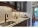 Chic bar area features granite countertops, glass cabinets, and a view into the home's living space at 633 Rolling Springs Dr, Cary, NC 27519