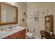 A classic powder room with a beautiful wood framed mirror, granite counter, and decorative wallpaper at 633 Rolling Springs Dr, Cary, NC 27519