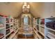 Custom closet with shelving and cushioned bench, illuminated by chandelier for organized luxury at 633 Rolling Springs Dr, Cary, NC 27519
