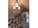 Walk-in closet illuminated with shelving, seating and a chandelier for stylish storage at 633 Rolling Springs Dr, Cary, NC 27519